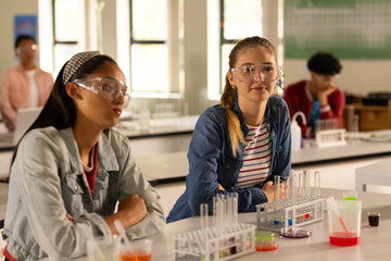 In high school, teenage girls wearing safety goggles attending chemistry class