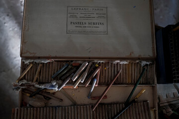 A box of vibrant pastels and pencils is placed on a table