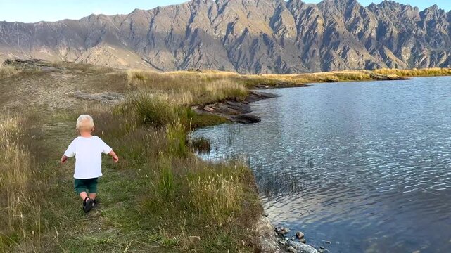 Toddler strolling along a Lord Of The Rings filming location and Deer Park Heights in Queenstown New Zealand. LOTR