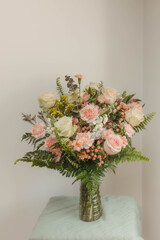 Elegant floral arrangement with pastel roses and ferns in a vase