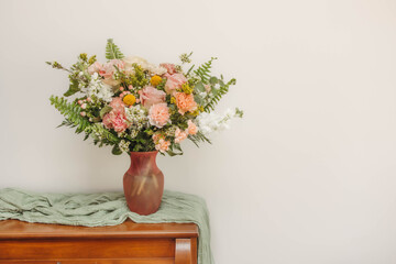 Elegant floral arrangement with pastel roses and ferns in a vase © Cavan