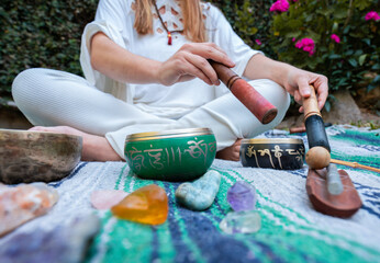unrecognized woman playing tibetan singing bowl