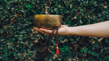 unrecognized woman playing tibetan singing bowl