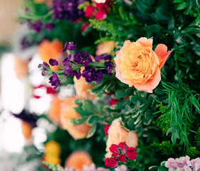 Vibrant floral arrangement with orange roses and purple flowers.