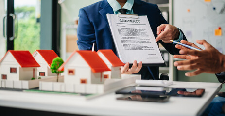 Real estate broker agent presenting and consult to customer to decision making sign insurance form agreement, home model