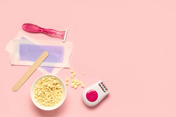 Modern epilator with razor, wax and strips on pink background