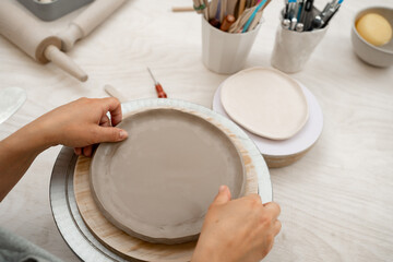 Building sides for clay products. Slab pottery. Creating ceramic products from flat sheets of clay. Using hands to model a form for a clay project.