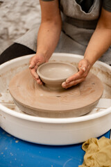 Wheel throwing. Learning how to model clay into different shapes with pottery wheel. Creating a ceramic bowl by yourself in a pottery class.