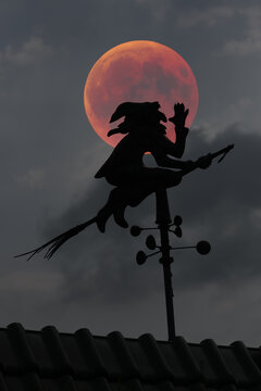 Blood moon over the roof of a house with weather vane with weather witch, Baden-W&uuml;rttemberg, Germany, Europe