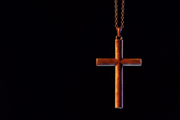 One cross with chain on black background, space for text. Religion of Christianity