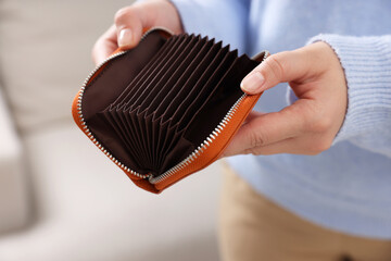 Woman with empty wallet indoors, closeup view