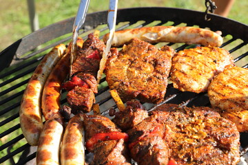 various meat and sausages on the charcoal grill