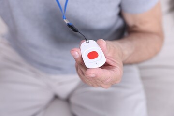 Senior man with emergency call button at home, closeup