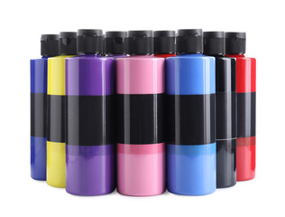 Acrylic paints of different colors in bottles isolated on white