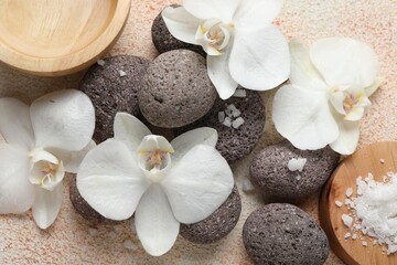 Naklejka na ściany i meble Spa stones, sea salt and beautiful orchid flowers on beige textured background, flat lay