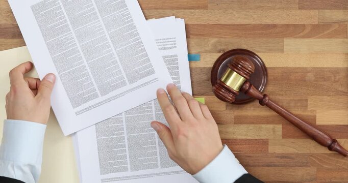 Blow of a judicial gavel and documents top view
