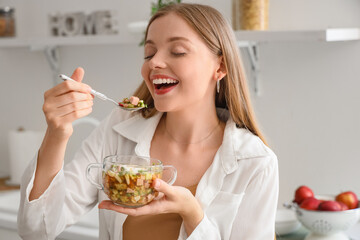Young woman eating tasty okroshka in kitchen, closeup