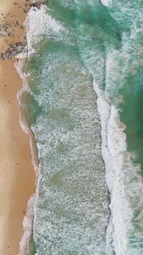 Phuket Thailand tropical beach Aerial drone top down view bird eye view of sea blue waves break on sand. Beautiful of sea water wave rip current reverse current undertow drone filming 4k vertical.