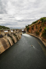 A spillway channel flowing alongside the dam wall and carrying enough water to maintain downstream...