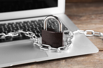 Padlock with chain on laptop, closeup. Cyber security concept
