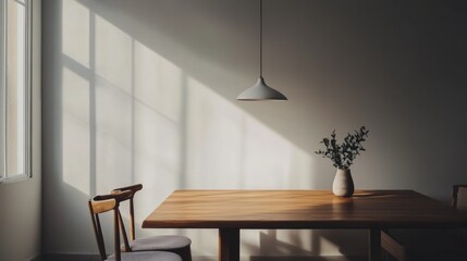 A minimalist dining area with a wooden table, four chairs, and a single pendant light.