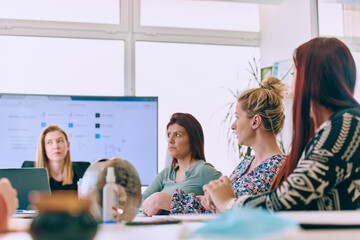 Fototapeta premium Diverse Business Team Discussing Projects in a Modern Glass Office.