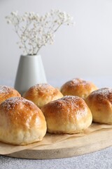 Delicious dough balls and flowers on grey table, closeup