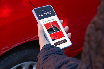 Reporting car damage through mobile technology. Woman standing by her car, holding a smartphone and sending photos of scratches on the vehicle for insurance purposes.