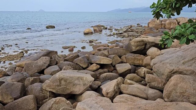 4k pan tilt a Hon Chong cape rock garden by the sea. Tourists travel walking on huge coastal boulders in Hon Chong rock garden in Nha Trang city, Vietnam.