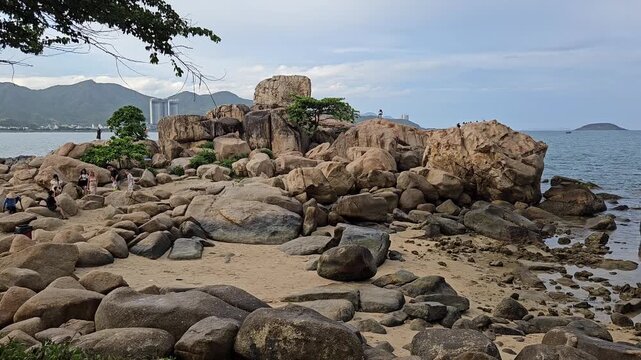 4k pan tilt a Hon Chong cape rock garden by the sea. Tourists travel walking on huge coastal boulders in Hon Chong rock garden in Nha Trang city, Vietnam.