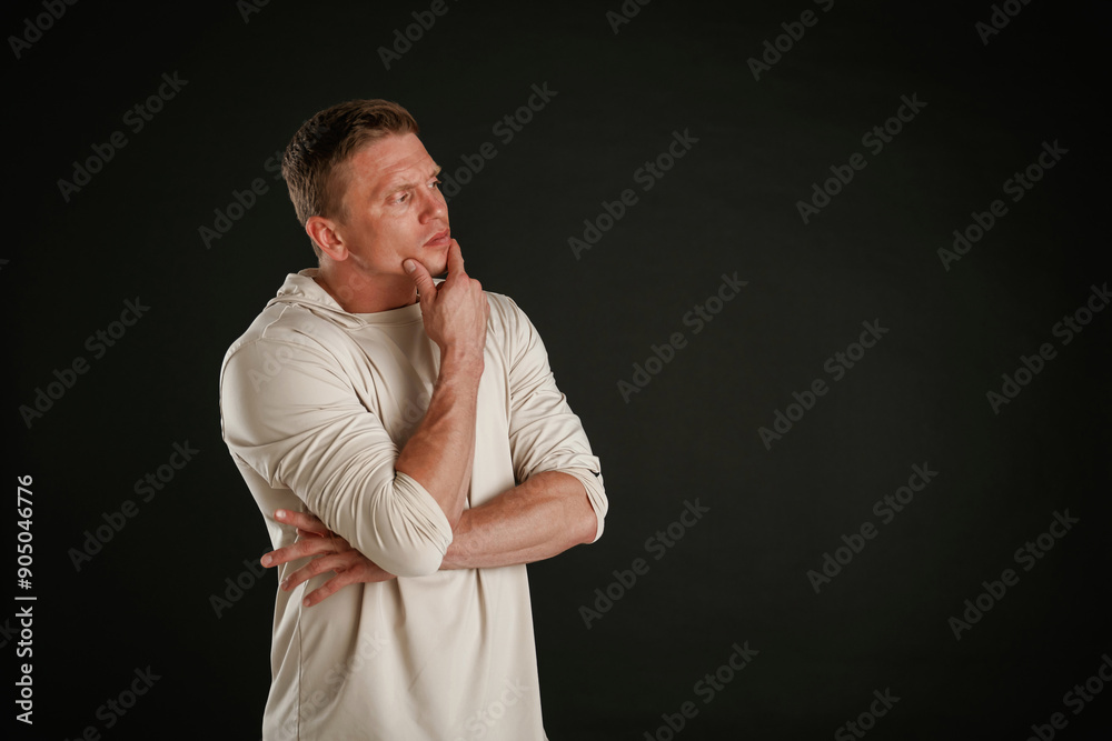 Wall mural Do you have any idea, standing and thinking. Man is against background in the studio