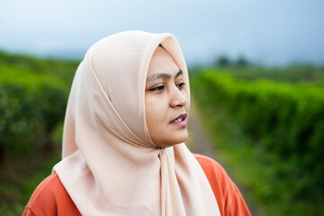 A Muslim woman is enjoying the panorama of the tea garden in the mountains