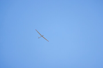 a glider flying in the blue sky