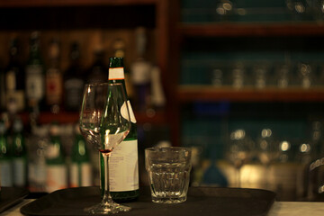 The tray with empty glasses and mineral water on a bar in a restaurant in Italy