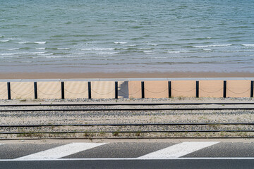 Obraz premium Artistic photo of Belgian coast featuring the sea, the promenade, tram tracks, and road. The vertical composition creates a graphic, almost abstract, representation of coastal elements, Middelkerke.