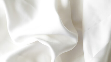 Crumpled white silk fabric background with soft folds and delicate texture.