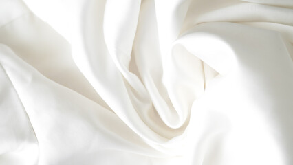 Obraz premium Crumpled white silk fabric background with soft folds and delicate texture.