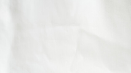 Crumpled white silk fabric background with soft folds and delicate texture.