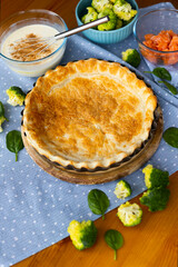 The process of making homemade French quiche pie with broccoli, spinach and salmon on blue plate