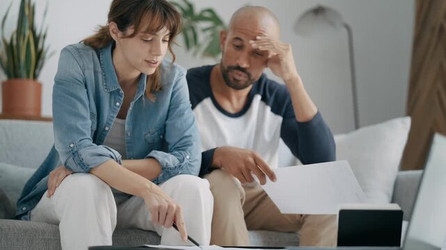 Couple discussing important documents sitting on the couch