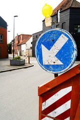 Belgian traffic sign indicating roadworks or obstruction ahead with orange hazard light. Sign instructs drivers to make way or divert due to construction or container on the road
