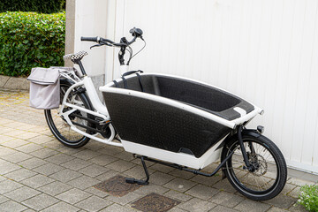 Electric cargo bike with front carrier for children, pets, or groceries. Popular urban transport solution gaining traction in traffic for eco-friendly and convenient commuting.