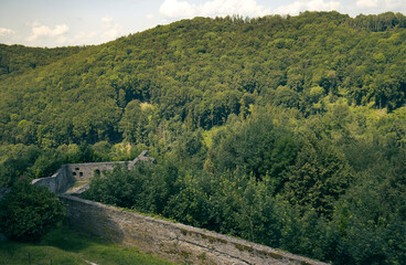 Naklejka premium photos of hills with forests and parts of the tribal castle building. Part of the castle and a view of the surrounding countryside. Forest, trees, hills, nature, blue sky with clouds.