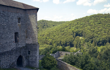 Fototapeta premium photos of hills with forests and parts of the tribal castle building. Part of the castle and a view of the surrounding countryside. Forest, trees, hills, nature, blue sky with clouds.
