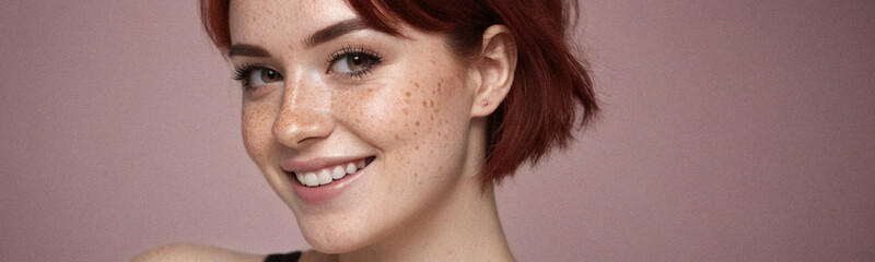 Fototapeta premium Portrait of a young red-haired woman with a bright smile in a minimalist style.