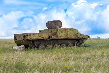 Rusty old soviet military vehicle wreck in a field