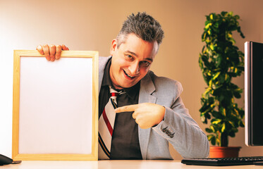 Sly salesman pointing at blank whiteboard in office