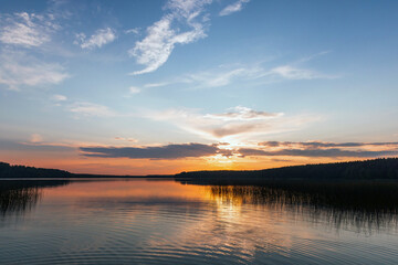 Dramatic sunset landscape with colorful clouds over still lake