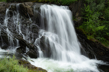 Obraz premium Small waterfall flowing over stones in the mountains of Rago, Northern Norway