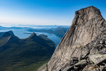 High steep rock walls on the Stetinden peak in North Norway with hikers and climbers trying to reach the summit